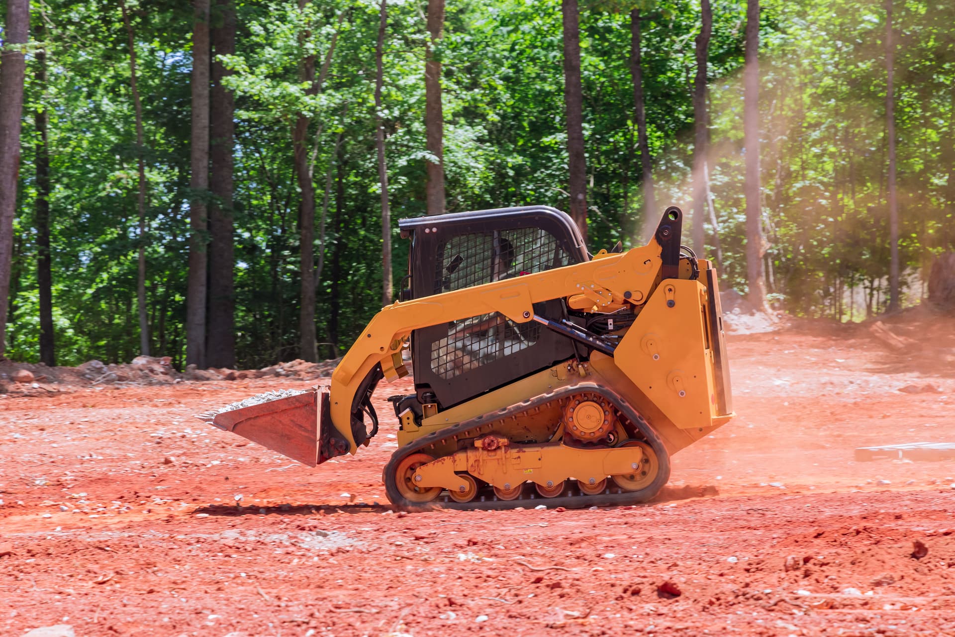 Compact track loader moving earth at construction site