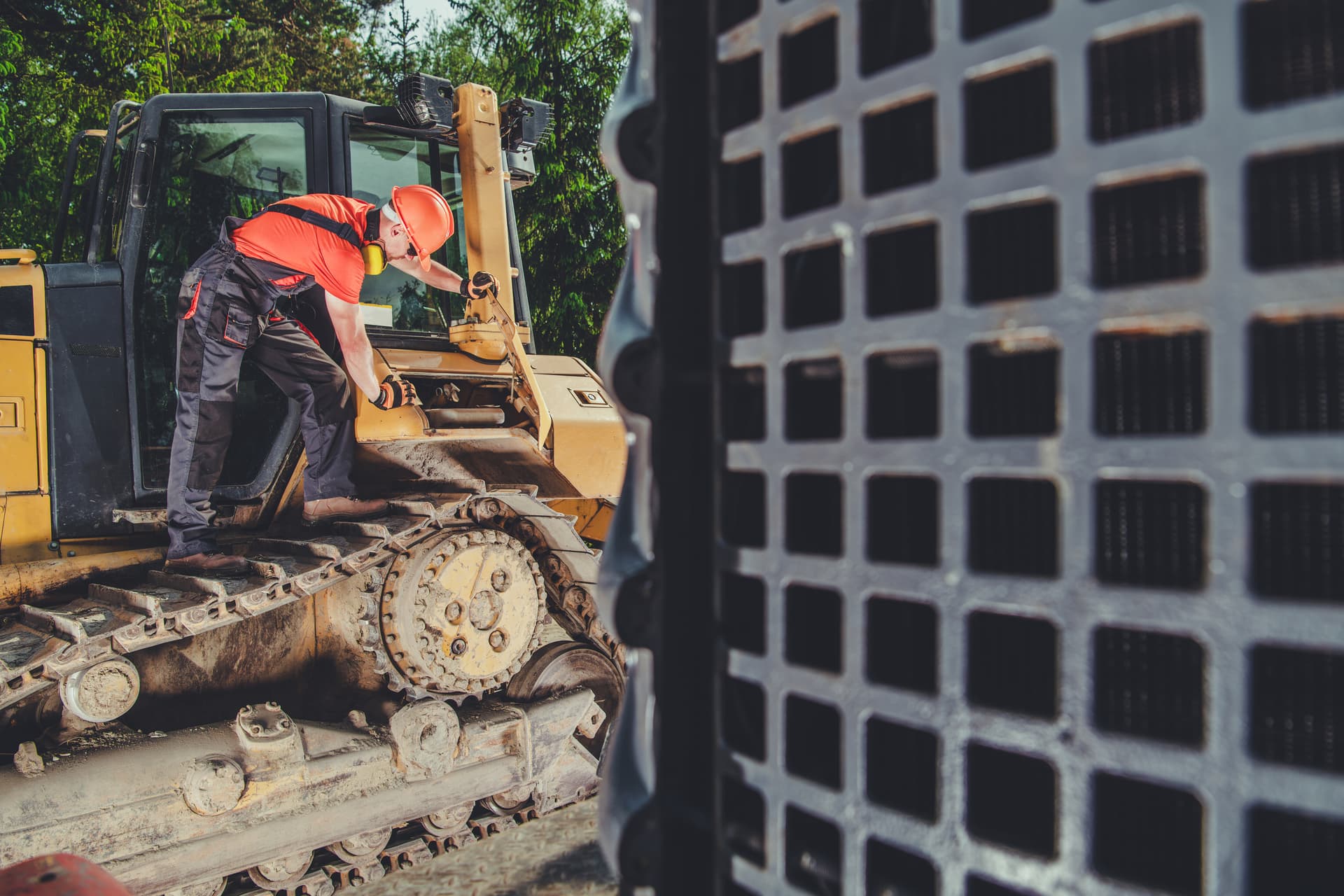 Professional mechanic inspecting bulldozer equipment